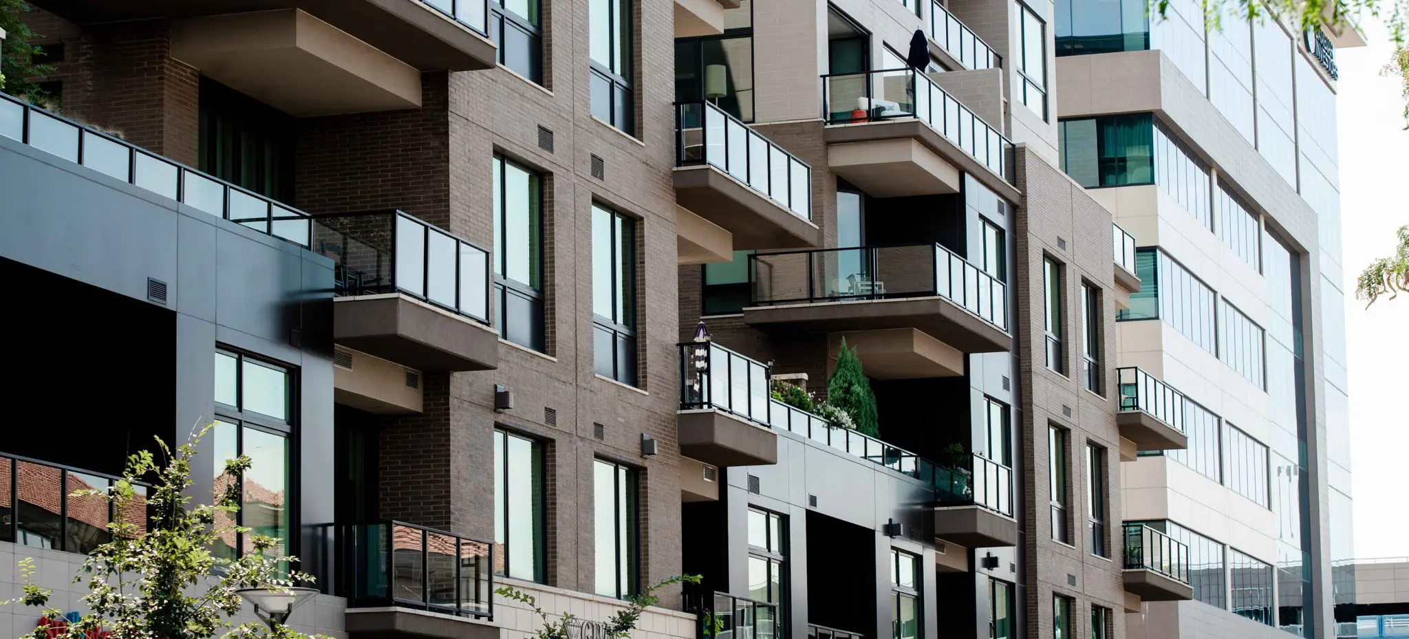 Modern apartment building with balconies and large windows provides safety and security for residents.