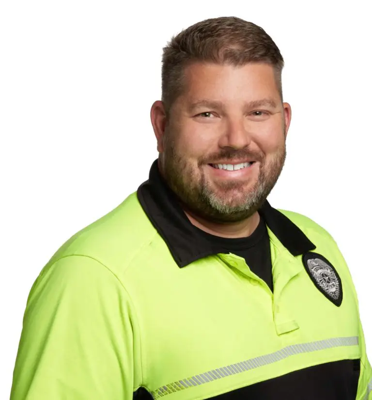 Smiling security guard in neon yellow and black uniform. Safety and Security professional portrait.