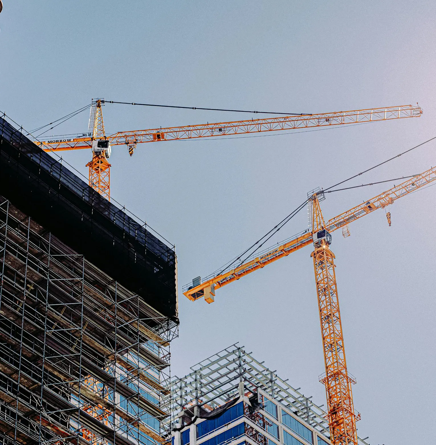 Construction site with cranes and scaffolding on buildings under development.