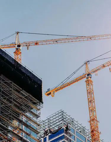 Construction site with cranes and scaffolding on a building under development.