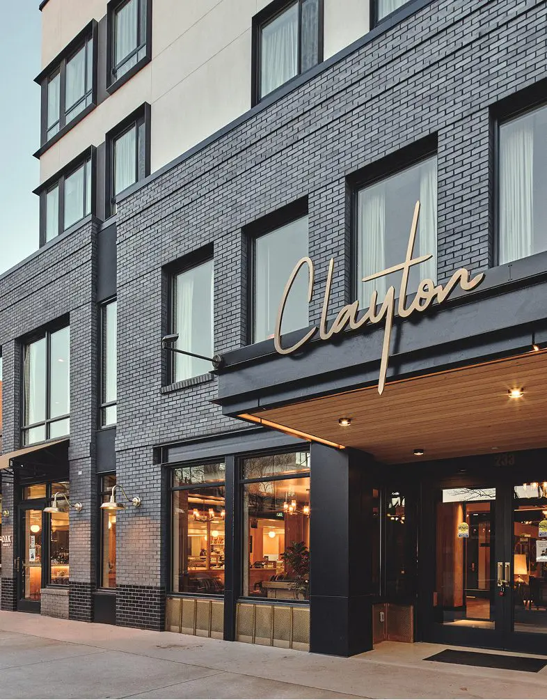 Clayton Hotel exterior with black brick and gold signage.