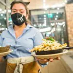 Waitress serving fries and soup at a restaurant. CCN 5 Star Certified service.