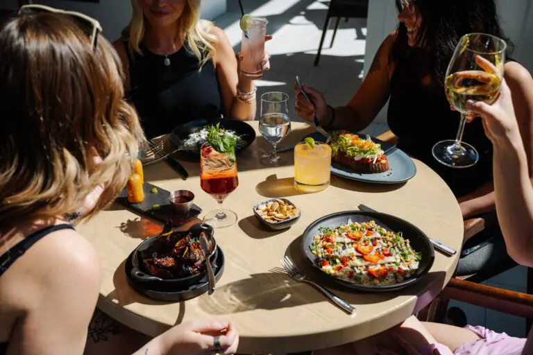 Group enjoying brunch with cocktails and food at a restaurant.