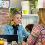 Blonde woman helping a customer at a store counter in Cherry Creek North.