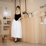 Taylor Eberhardt of Lou Collective stands in her boutique with a cute dog.