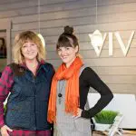 Two women at VIVE Float Studio+ reception desk, smiling for the camera.