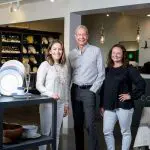 Three people stand in the White Peacock store.