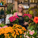 Woman florist at Bloom, a women-owned business in Cherry Creek North, holding pink kalanchoe flowers.