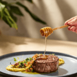 Honey being drizzled on a filet mignon steak dish with polenta and vegetable salsa. Viva Abejas.