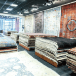 Kian Rugs Co. showroom with stacks of colorful, patterned oriental rugs on display.