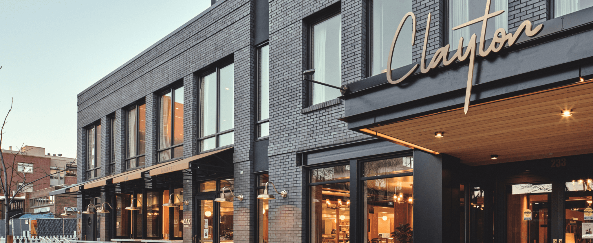 The Clayton Hotel exterior with modern black brick, large windows, and stylish signage.