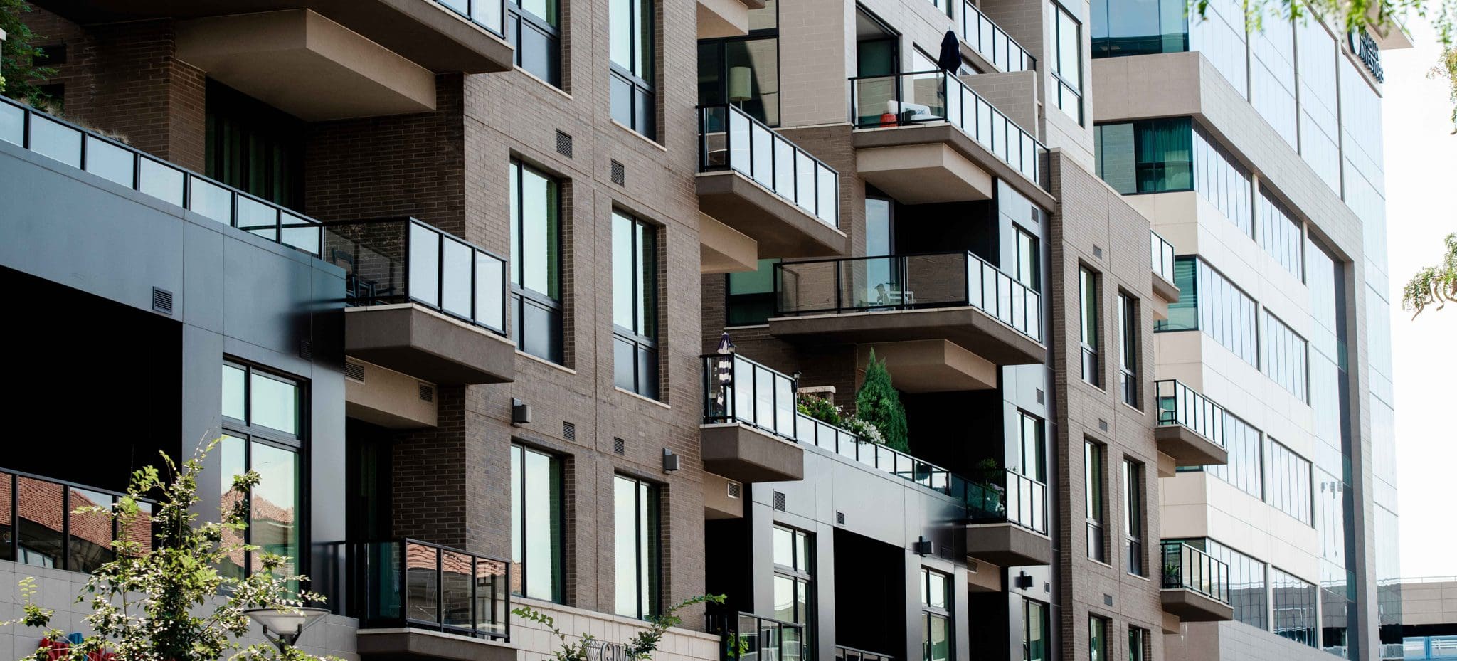Modern apartment building with balconies and large windows provides safety and security for residents.