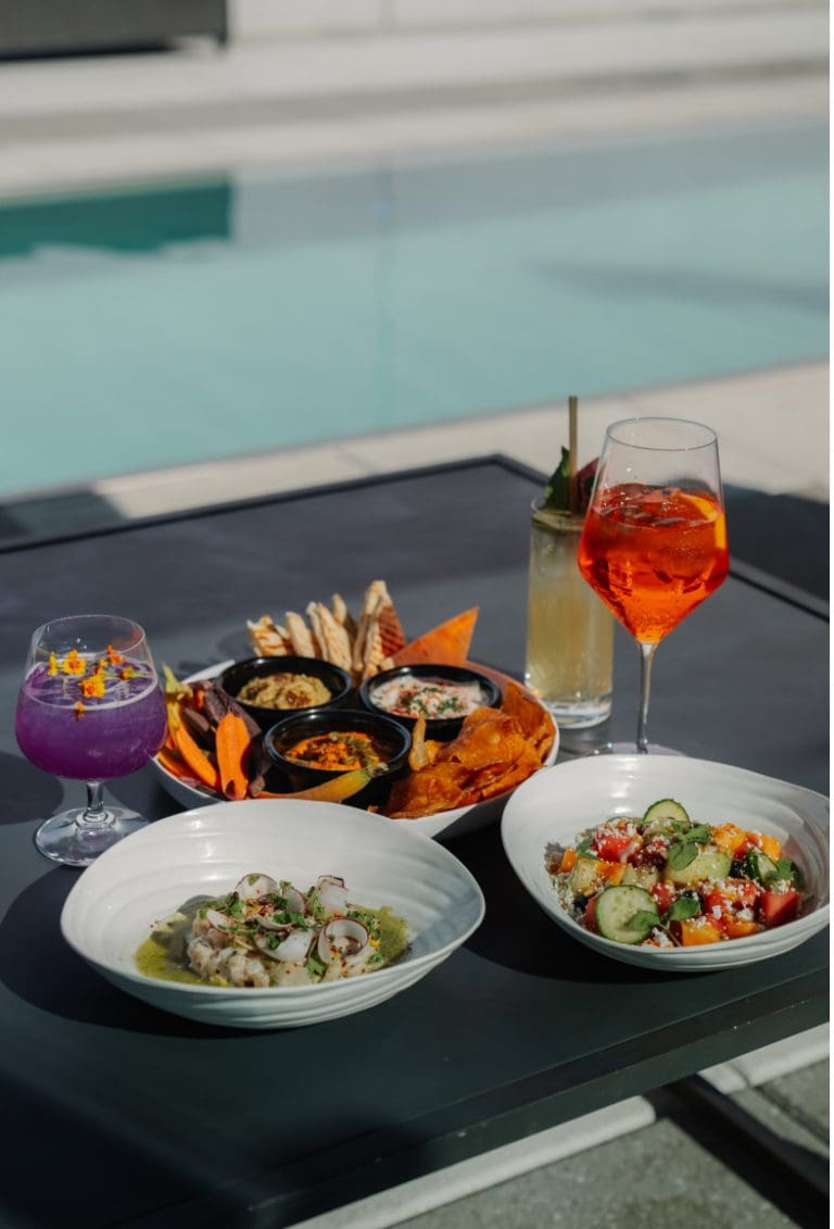Delicious poolside spread: dips, salads, cocktails, and vibrant colors.