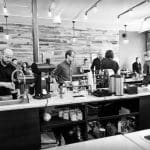 Busy baristas at Aviano Coffee prepare drinks for customers, showcasing the cafe's atmosphere.