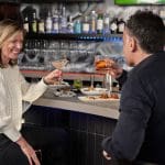 Couple toasting cocktails at a Denver date night restaurant bar.