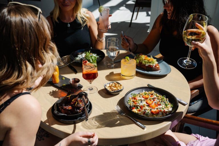 Group enjoying brunch with cocktails and food at a restaurant.