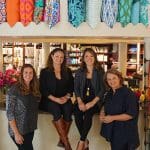 The Brass Bed store staff with colorful linens and pillows on display.