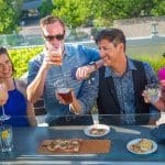Friends enjoy drinks and pizza at a Cherry Creek North rooftop bar.