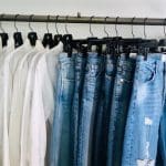 Clothes rack with white shirts and blue jeans, perfect for Spring Cleaning with Kouture Consignment.