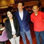 Three people smiling inside Mehak India's Aroma restaurant.