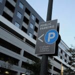 Public parking sign for Cherry Creek North with a parking garage in the background.