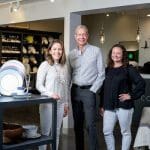 Three people stand in the White Peacock store.