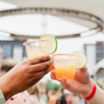 Two people toasting with colorful margaritas at 5280 Top of the Town event.