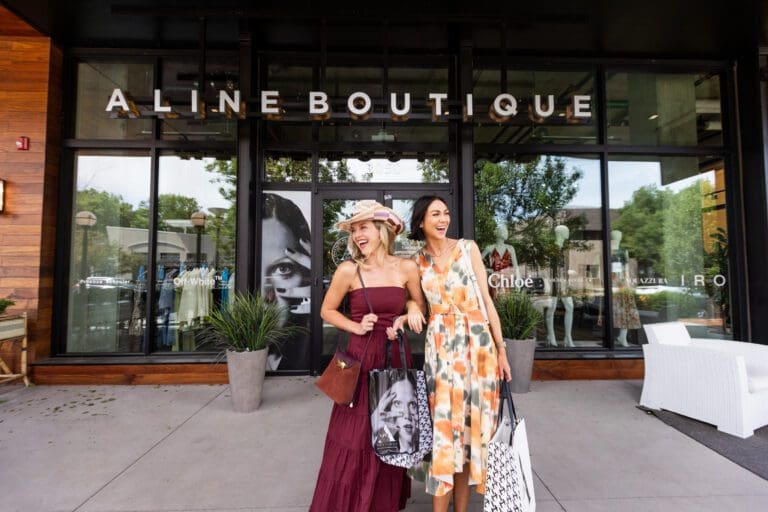 Two women walking out of A Line Boutique