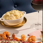 Sliced steak with shrimp, mashed potatoes, and red wine, a fine dining meal